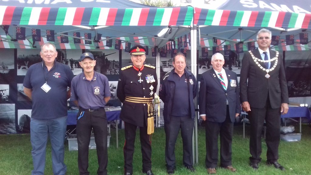 Chris Jones and team standing in front of SAMA 82 gazebo during an event in Plymouth.